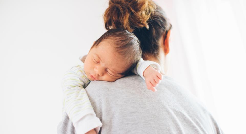 Newborn baby sleeping on mothers shoulder