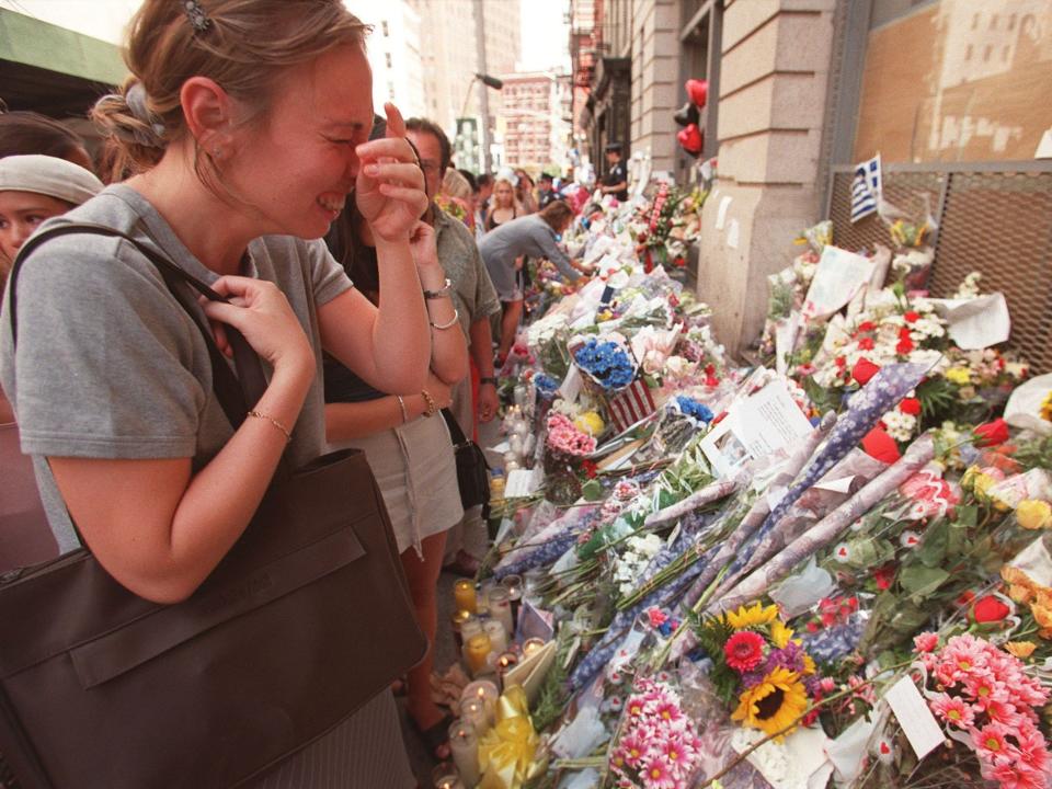 A mourners cries as people pay respects at the floral shrine outside of the building where John F. Kennedy Jr. and Carolyn lived in 1999.