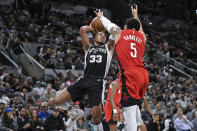 San Antonio Spurs' Tre Jones (33) goes to the basket as Houston Rockets' Fred VanVleet defends during the first half of an NBA basketball game Tuesday, March 12, 2024, in San Antonio. (AP Photo/Darren Abate)