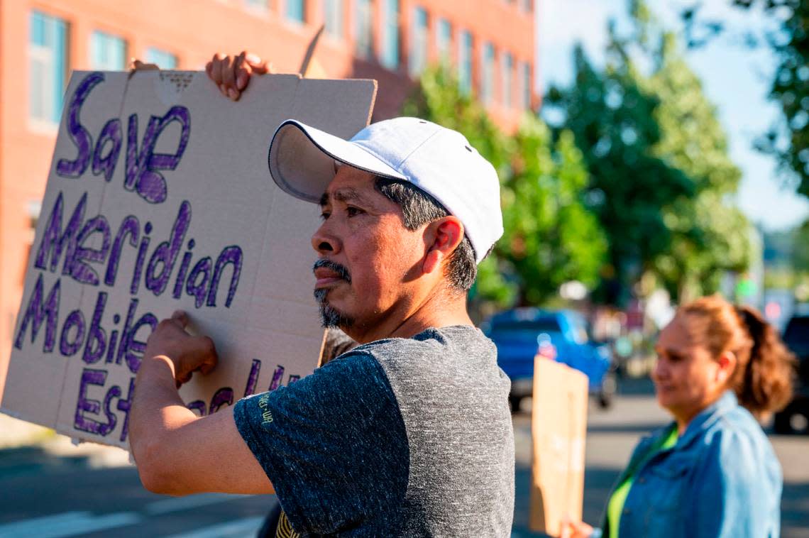 Martin Martinez, a resident at Meridian Mobile Estates, holds up a sign, while standing outside of Puyallup City Hall during a rally prior to a Puyallup City Council meeting on Tuesday, Aug. 23, 2022.