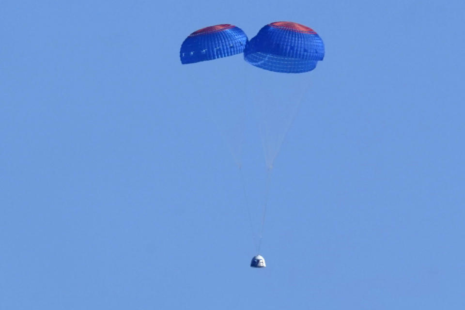 Paracaídas transportan la cápsula de Blue Origin con los pasajeros William Shatner, Chris Boshuizen, Audrey Powers y Glen de Vries hasta el puerto espacial cerca de Van Horn, Texas, el miércoles 13 de octubre de 2021. (AP Foto/LM Otero)