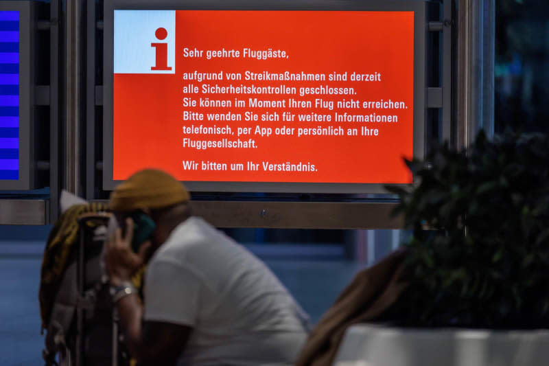 A monitor provides information about the strike in the waiting area at one of 11 major German airports that have started a one-day strike. Jörg Halisch/dpa