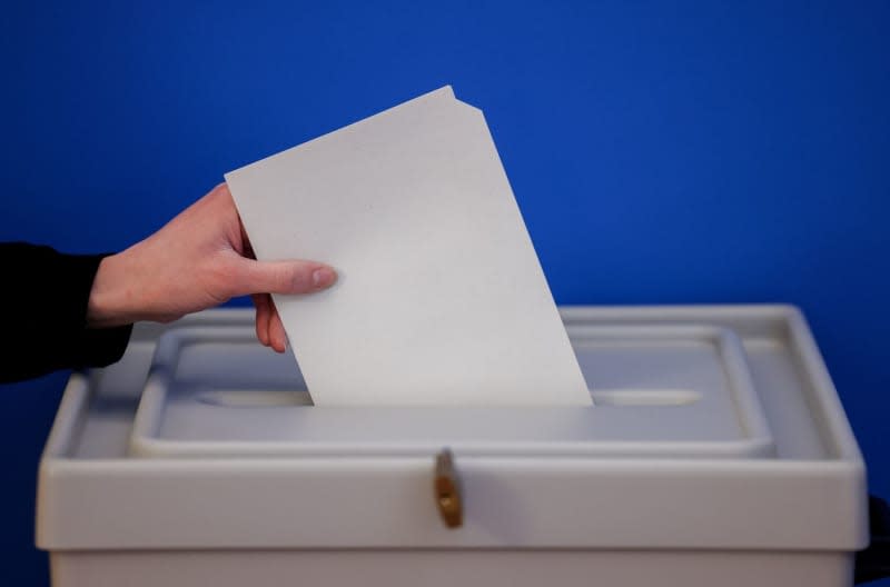 A woman casts a ballot paper for the European elections. For the first time, people in Germany aged 16 and over will be allowed to cast a ballot in the European elections in two weeks' time, in a milestone for voting rights in the country. Jan Woitas/dpa
