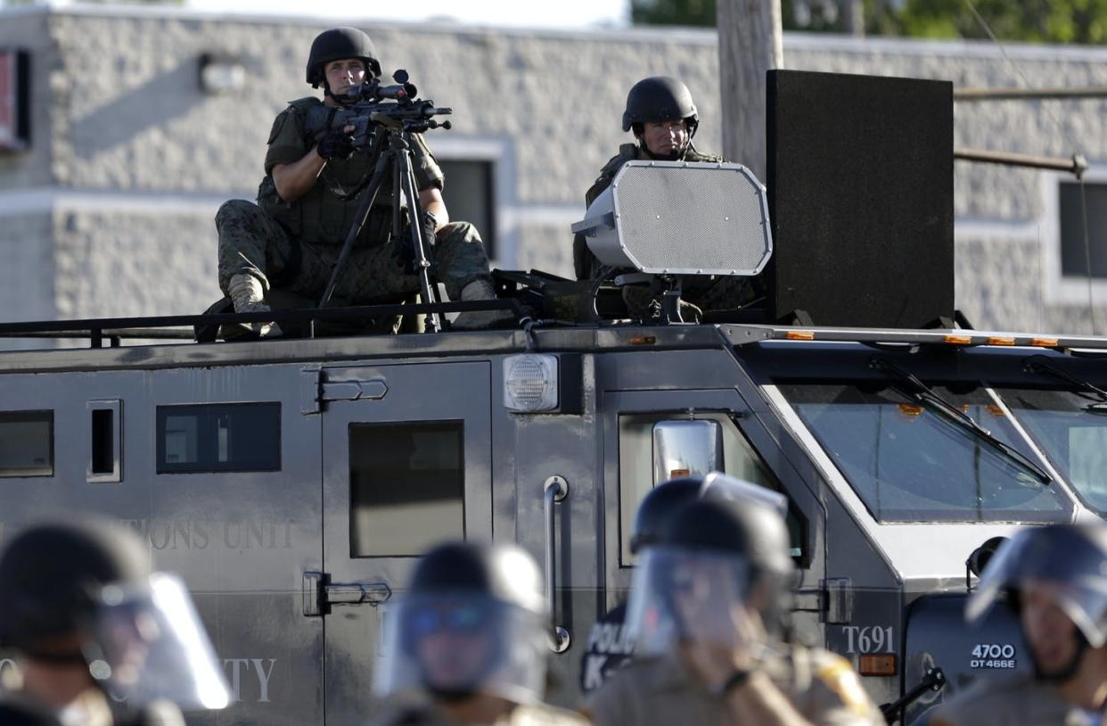 <span class="caption">A police tactical team in Ferguson, Mo., responds to 2014 protests against a white officer's killing of Michael Brown, a young Black man.</span> <span class="attribution"><a class="link " href="http://www.apimages.com/metadata/Index/Trump-Police-Military-Gear/5e071ec6710d4ec3a876fdec7cb13b78/2/0" rel="nofollow noopener" target="_blank" data-ylk="slk:AP Photo/Jeff Roberson;elm:context_link;itc:0;sec:content-canvas">AP Photo/Jeff Roberson</a></span>