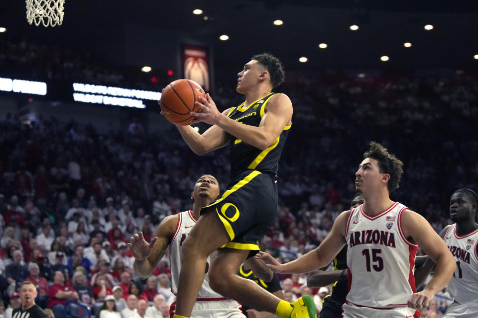 Oregon guard Jesse Zarzuela drives past Arizona forward Keshad Johnson and guard Grant Weitman (15) during the first half of an NCAA college basketball game, Saturday, March 2, 2024, in Tucson, Ariz. (AP Photo/Rick Scuteri)