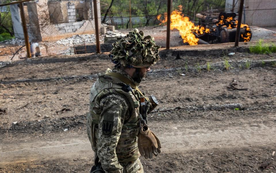 A Ukrainian soldier walks past a burning gas terminal on the northern outskirts of Kharkiv - John Moore/Getty Images Europe