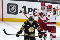 Carolina Hurricanes left wing Teuvo Teravainen (86) is congratulated by Andrei Svechnikov (37) after his goal during the second period of an NHL hockey game, Tuesday, April 9, 2024, in Boston. In foreground is Boston Bruins defenseman Charlie McAvoy (73). (AP Photo/Charles Krupa)