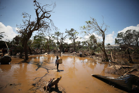 A child walks past debris as flood waters begin to recede in the aftermath of Cyclone Idai, in Buzi near Beira, Mozambique March 24, 2019. REUTERS/Mike Hutchings