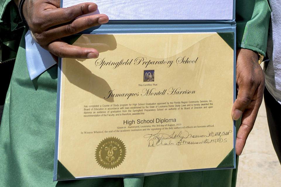Jamarques Harrison, 28, holds his diploma backdated to Aug. 3, 2013, after graduating with the class of Springfield Preparatory School at Victory in Christ church in Holden, La., Saturday, Aug. 5, 2023. Nearly 9,000 private schools in Louisiana don’t need state approval to grant degrees. Non-approved schools make up a small percentage of the state total. But the students in Louisiana’s off-the-grid school system are a rapidly growing example of the national fallout from COVID-19 — families disengaging from traditional education. (AP Photo/Matthew Hinton)