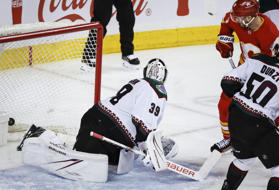 Arizona Coyotes goalie Connor Ingram (39) lets in a goal as Calgary Flames forward Jonathan Huberdeau (10) looks on during the third period of an NHL hockey game in Calgary, Alberta, Sunday, April 14, 2024. (Jeff McIntosh/The Canadian Press via AP)