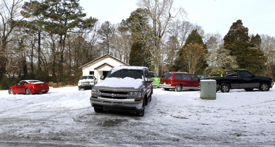 Cars are left in a vacant church parking lot as drivers abandoned their vehicles and walked home or found shelter nearby on Wednesday, Jan. 29, 2014, in Indian Springs, Ala. A winter storm caught much of Alabama off guard and thousands of people spent the night at work, school, and on roadways in their cars. (AP Photo/Butch Dill)