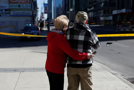 A couple look down the road after an incident where a van struck multiple people at a major intersection in north Toronto, Ontario, Canada, April 23, 2018. REUTERS/Chris Donovan