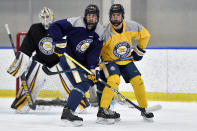 Canisius left wing Alton McDermott, right, and defenseman Tyrell Buckley during an NCAA college hockey practice in Buffalo, N.Y., Thursday, Jan. 26, 2023. McDermott's grandfather, former NHLer Paul Henderson, scored the decisive goal in clinching Canada its Summit Series win over Russia some 50 years ago and will celebrate his 80th birthday with a ceremonial puck drop before Cansius' game against Niagara. (AP Photo/Adrian Kraus)