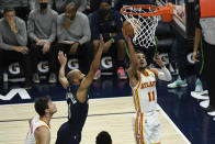 Atlanta Hawks guard Trae Young (11) goes up to shoot past Minnesota Timberwolves guard Jordan McLaughlin during the second half of an NBA basketball game Monday, Dec. 6, 2021, in Minneapolis. (AP Photo/Craig Lassig)