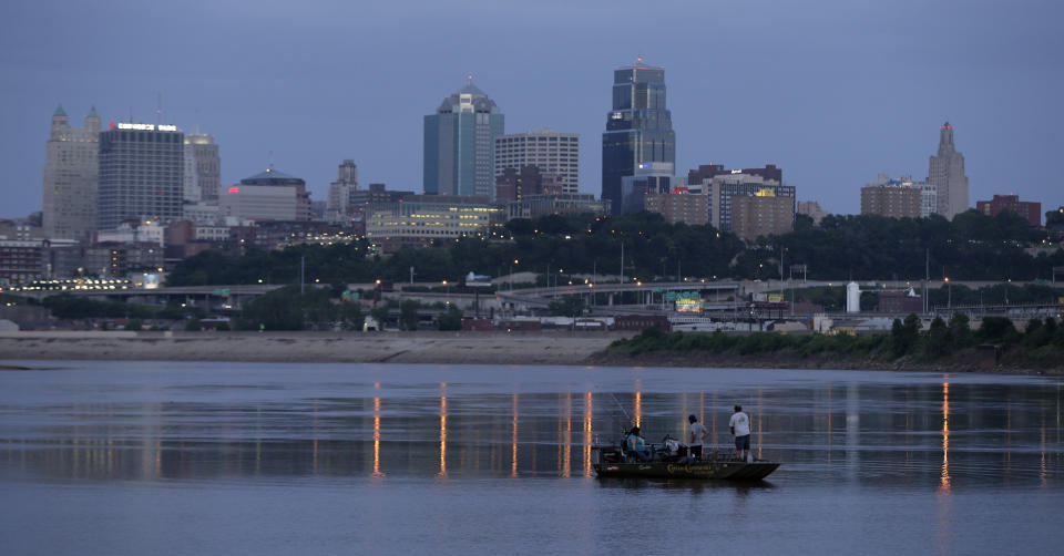 FILE - In this Sunday, June 23, 2013, file photo, people fish in the Missouri River along the banks of downtown Kansas City, Mo. Amazon's final cut of 20 contenders for its second headquarters leaves hundreds of cities disappointed. That includes hopefuls like Detroit, Memphis, Tenn., and Kansas City, Mo. (AP Photo/Charlie Riedel, File)