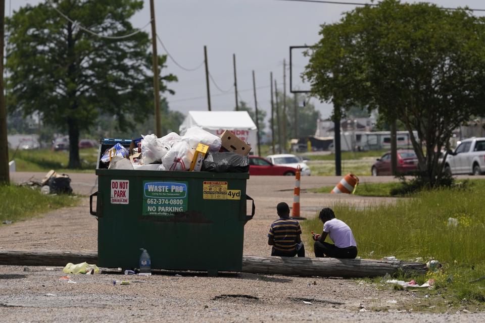 Children sit outside the Rolling Fork Motel, where displaced families are living after their homes were destroyed from the recent deadly tornado, in Rolling Fork, Miss., Tuesday, May 9, 2023. Tornadoes in the United States are disproportionately killing more people in mobile or manufactured homes, especially in the South. (AP Photo/Gerald Herbert)