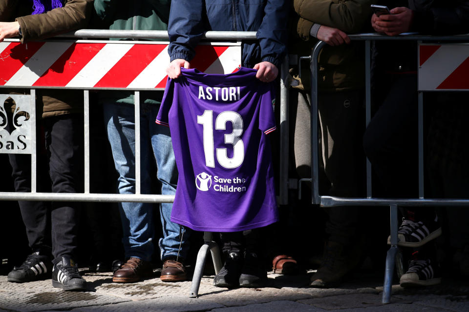 <p>Außerhalb der Kirche hält jemand ein Astori-Trikot über die Absperrung. (Bild: REUTERS/Alessandro Bianchi) </p>