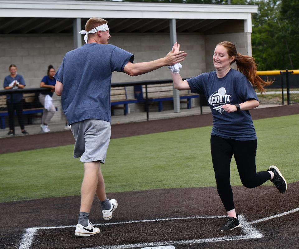 Kicking Assets' Christina Nye high-fives Tyler Livingston after scoring a run against the Chicken Kickers during the Kickin' It - Kickball Tournament with Mission Win at the New England Baseball Complex in Northborough on Aug. 17.
