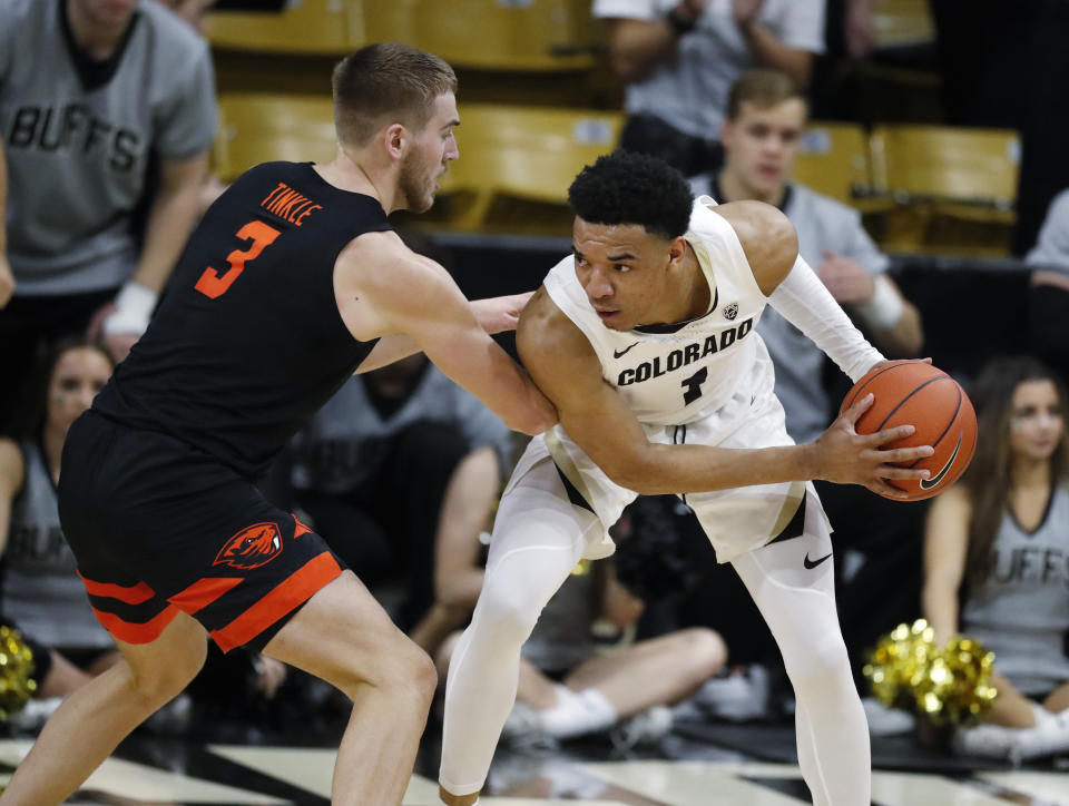 Colorado guard Tyler Bey, right, looks to pass the ball as Oregon State forward Tres Tinkle defends in the first half of an NCAA college basketball game Sunday, Jan. 5, 2020, in Boulder, Colo. (AP Photo/David Zalubowski)