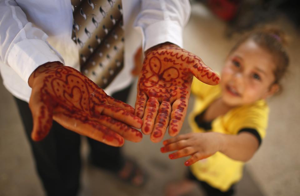 Young Palestinian groom Soboh shows traditional paint on his hands before wedding party to bride Tala, in town of Beit Lahiya