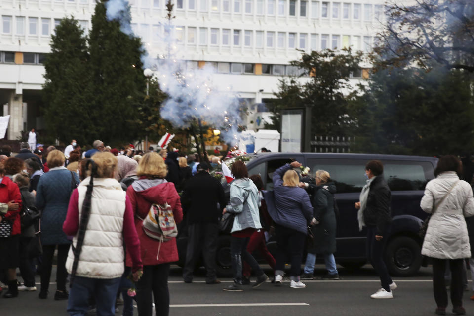 People, most of them elderly women, argue with plainclothes policemen sitting in a van during an opposition rally to protest the official presidential election results in Minsk, Belarus, Monday, Oct. 12, 2020. Riot police clashed with protesting pensioners in central Minsk on Monday. The pensioners marched in a column through central Minsk, carrying flowers and posters with slogans such as "The grandmas are with you (protesters)." (AP Photo)