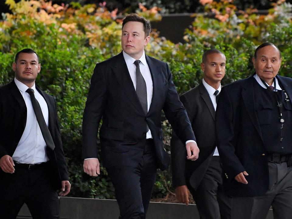 Tesla CEO Elon Musk, second from left, arrives at U.S. District Court Wednesday, Dec. 4, 2019, in Los Angeles. Musk is going on trial for his troublesome tweets in a case pitting the billionaire against a British diver he allegedly dubbed a pedophile. (AP Photo/Mark J. Terrill)