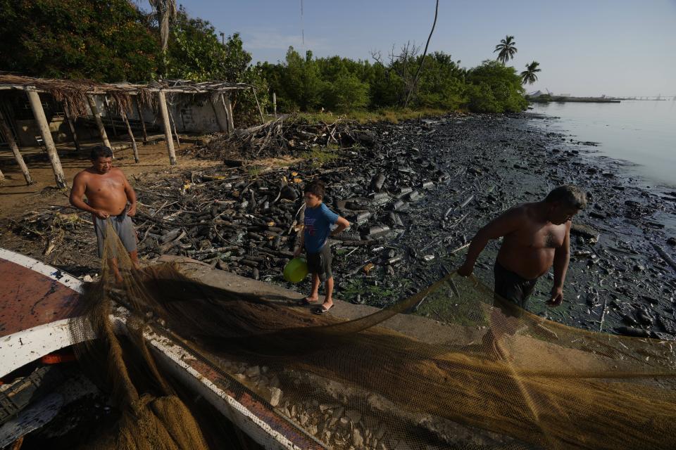 Pescadores estiran sus redes en la ribera del Lago de Maracaibo contaminado con petróleo y desechos en el agua, en San Francisco, Venezuela, el miércoles 9 de agosto de 2023. La contaminación en torno al lago, uno de los más grandes de América Latina, es resultado de décadas de excesiva explotación petrolera en su lecho, mantenimiento inadecuado y falta de inversión en una infraestructura obsoleta, según ambientalistas. (AP Foto/Ariana Cubillos)