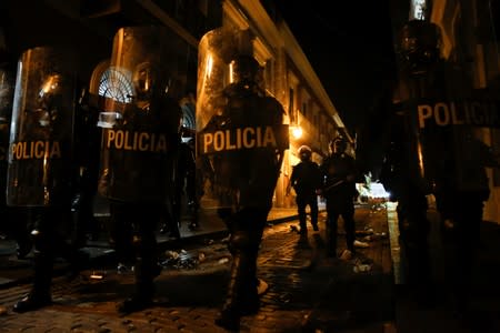 Police clash with demonstrators during a protest calling for the resignation of Governor Ricardo Rossello in San Juan