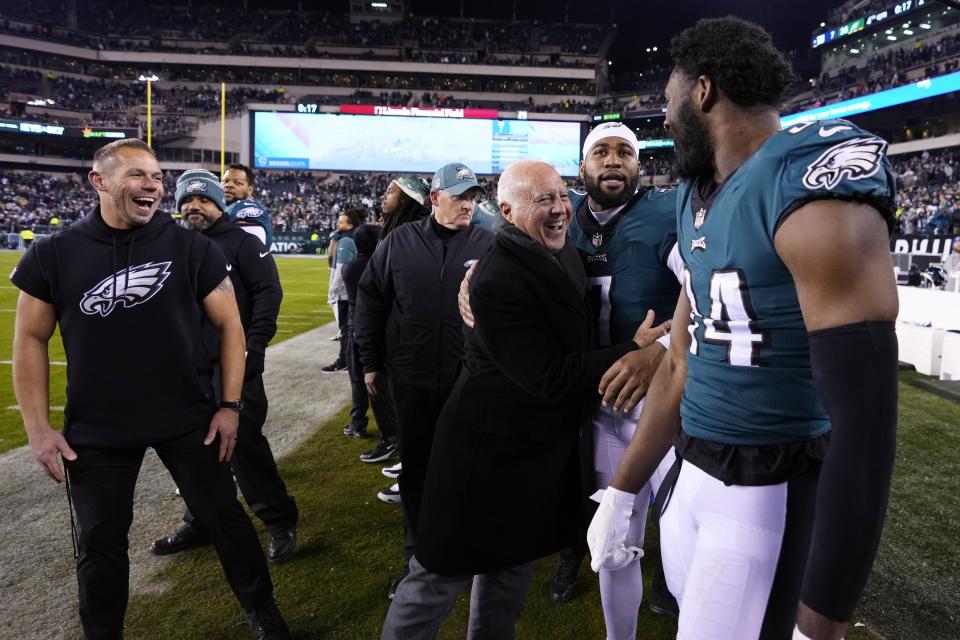 Philadelphia Eagles owner Jeffrey Lurie, center, reacts with linebacker Haason Reddick (7) and defensive end Josh Sweat (94) following an NFL divisional round playoff football game against the New York Giants, Saturday, Jan. 21, 2023, in Philadelphia. The Eagles won 38-7. (AP Photo/Matt Slocum)