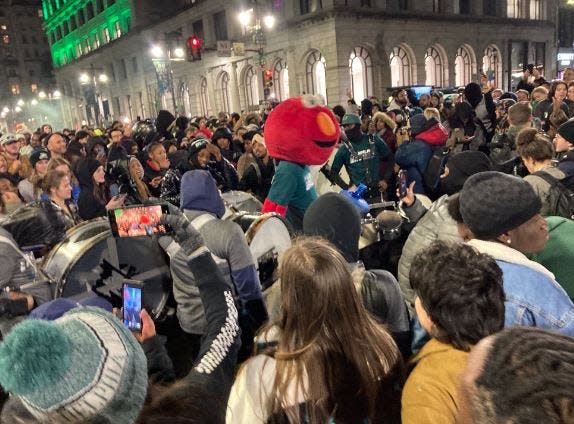 An Eagles fan wearing a Muppet head joins a crowd on Philadelphia's Broad Street after the Super Bowl.