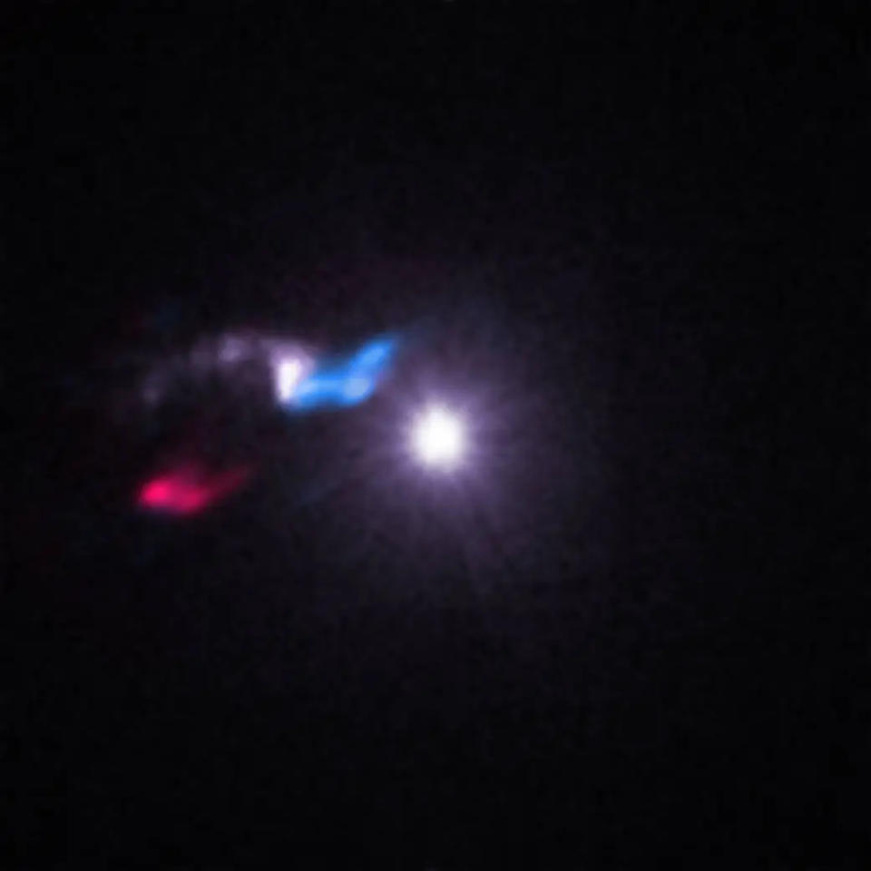 a few blurry splotches of white, red and blue light in the blackness of space.