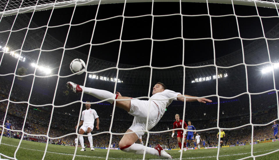 FILE - In this June 19, 2012 filer, England's John Terry clears the ball away from his goal during the Euro 2012 soccer championship Group D match between England and Ukraine in Donetsk, Ukraine. UEFA has called on FIFA's law-making panel to delay a decision on approving goal line technology next week. The European football body also pledged full support Saturday for its rival five-officials method of refereeing promoted by its president Michel Platini, despite an obvious error which denied Ukraine a goal in a decisive European Championship group match against England. (AP Photo/Matthias Schrader, File)