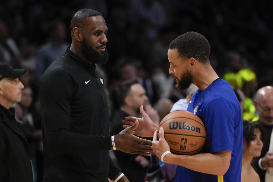 Los Angeles Lakers forward LeBron James, left, and Golden State Warriors guard Stephen Curry greet each other before their NBA basketball game in Los Angeles, Saturday, March 16, 2024. (AP Photo/Ashley Landis)