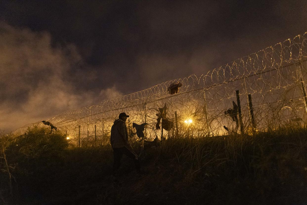 TOPSHOT - EDITORS NOTE: Graphic content / Smoke from make shift fires fills the air as migrants wait to enter and seek asylum in El Paso, Texas from Ciudad Juarez, Chihuahua, Mexico on April 2, 2024. An appeals court is scheduled to hear arguments on the constitutionality of Senate Bill 4 that would allow state law enforcement officials to detain and arrest undocumented immigrants suspected of illegally crossing into the United States. (Photo by CHRISTIAN MONTERROSA / AFP) (Photo by CHRISTIAN MONTERROSA/AFP via Getty Images)