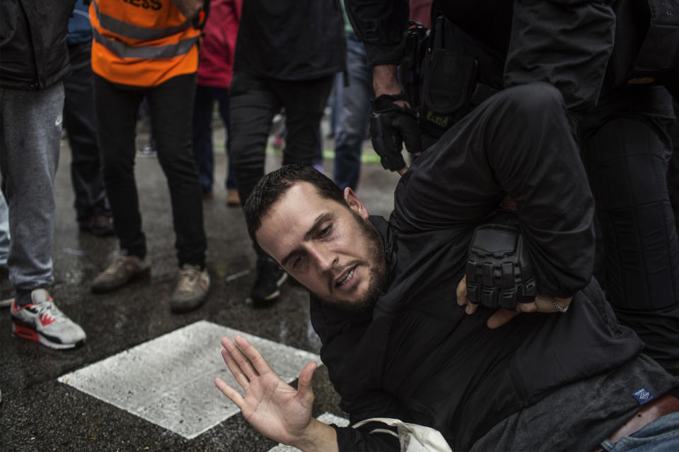 <p>A Spanish police officer grabs a man during clashes outside the Ramon Llull polling station in Barcelona Oct.1, 2017 during a referendum on independence for (Photo: Fabio Bucciarelli/AFP/Getty Images) </p>