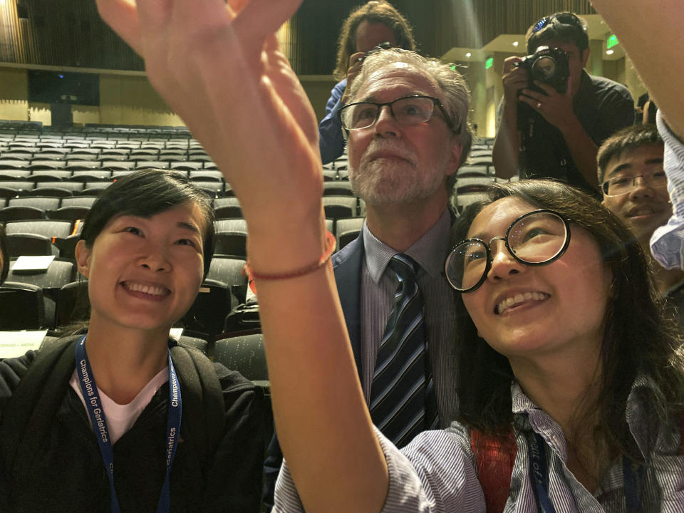 Professor Gregg Semenza take pictures with students during a news conference after he was awarded the 2019 Nobel Prize for Physiology or Medicine at Johns Hopkins Medicine Hospital in Baltimore, Monday, Oct. 7, 2019. Semenza shares the prize with Drs. William G. Kaelin Jr. and Peter J. Ratcliffe for their discoveries of how cells sense and adapt to oxygen availability, the Nobel Committee announced Monday. (AP Photo/Jose Luis Magana)