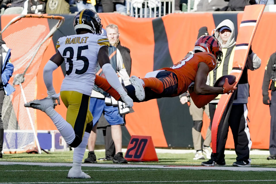 Cincinnati Bengals wide receiver Tyler Boyd (83) makes a diving catch past Pittsburgh Steelers cornerback Arthur Maulet (35) during the first half of an NFL football game, Sunday, Nov. 28, 2021, in Cincinnati. (AP Photo/Jeff Dean)