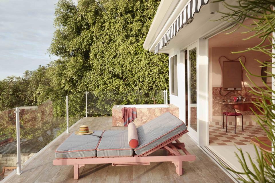 a deck with a table and chairs on it and trees in the back