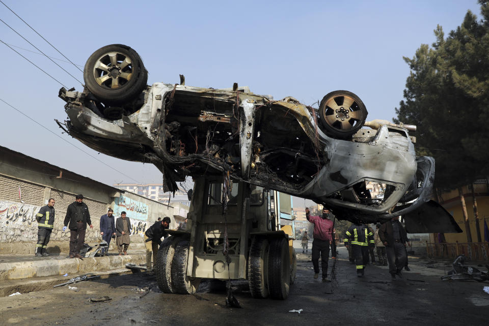 FILE - In this Jan. 10, 2021 file photo, Afghan security personnel remove a damaged vehicle after a deadly roadside bomb attack in Kabul, Afghanistan. In a report released Monday, Feb. 1, 2021, the Special Inspector General for Afghanistan Reconstruction, known as SIGAR, that monitors the billions of dollars the U.S. spends in Afghanistan, said that Taliban attacks in the Afghan capital Kabul are on the rise, with increasing targeted killings of government officials, civil-society leaders and journalists. (AP Photo/Rahmat Gul, File)