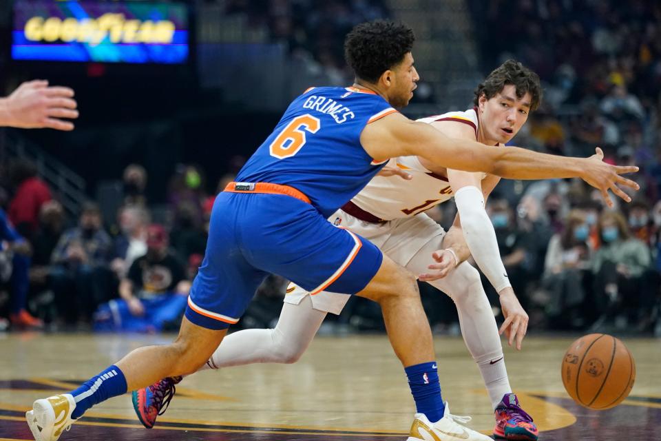 Cavaliers forward Cedi Osman, right, passes against New York Knicks guard Quentin Grimes in the first half of the Cavs' 95-93 win Monday night in Cleveland. [Tony Dejak/Associated Press]