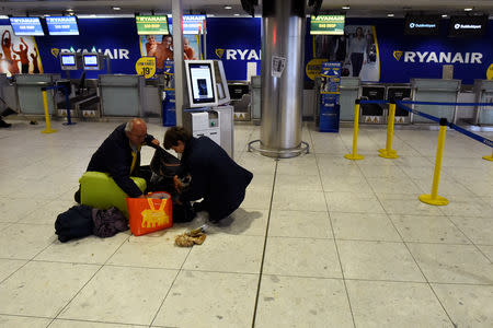 FILE PHOTO: People rearrange the weight of their luggage in the Ryanair check-in section of the Departures area at Dublin airport in Dublin, Ireland September 27, 2017. REUTERS/Clodagh Kilcoyne