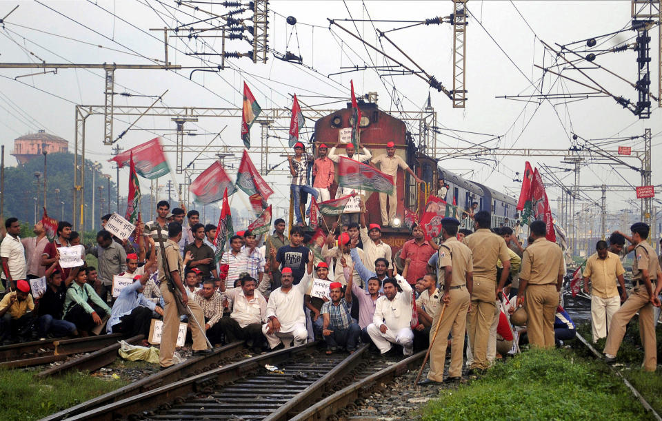 Samajwadi Party activists block a train during a strike in Allahabad, India, Thursday, Sept. 20, 2012. Angry demonstrators disrupted trains and forced some shops and schools to close Thursday in a partly successful national strike protesting a government decision to cut fuel subsidies and open India's huge retail market to foreign companies. (AP Photo)