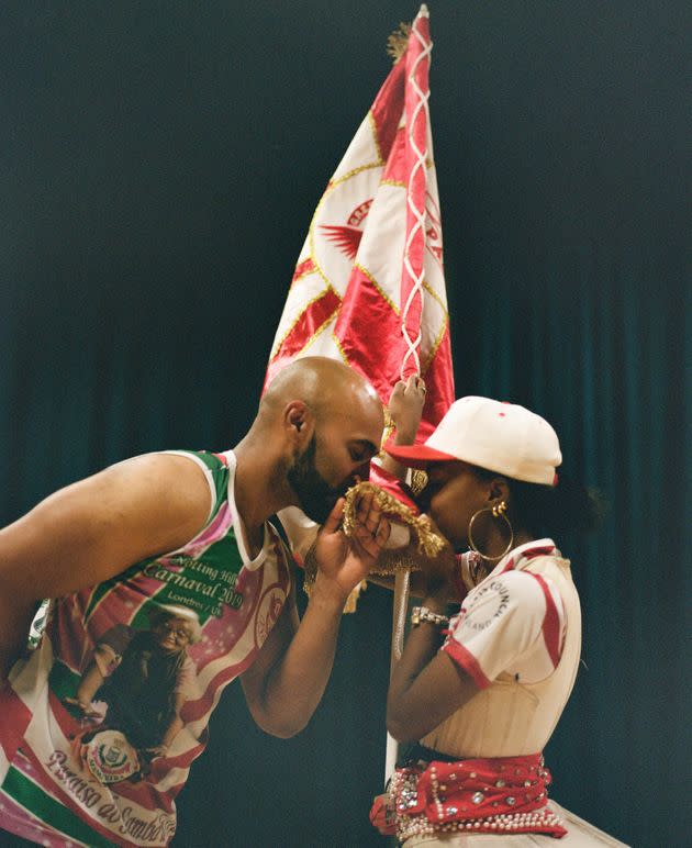 Amber Ogunsanya-William and Chirag Goyate kiss the Paraiso School of Samba flag, a tradition in Brazilian culture. (Photo: Clara Watt for HuffPost)