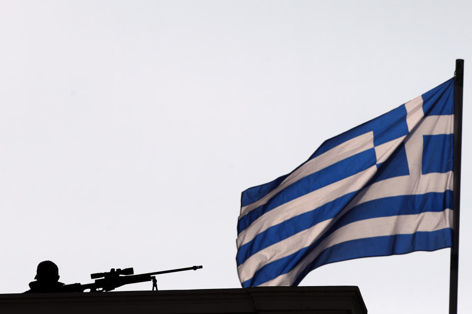 A Police special forces' sniper stands on the rooftop of Zappeion during a Eurogroup meeting, in Athens on Tuesday, April 1, 2014. Finance ministers from the eurozone and the wider European Union are gathering in Athens amid tight security, with Greece hoping for a gesture of support for the release of long-delayed funds from the country's multi-billion-euro bailout. (AP Photo/Kostas Tsironis)