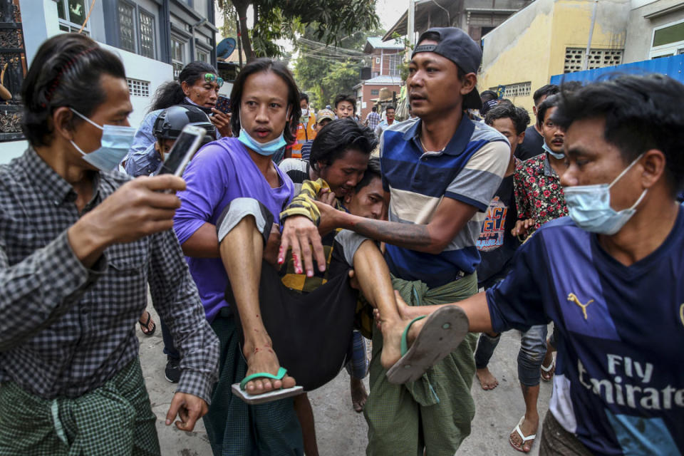 2021年2月20日，緬甸曼德勒警察驅散示威者，一名受傷男子被抬走。