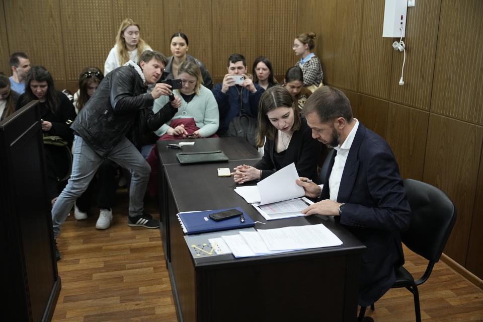 Lawyers of TV presenter and actress Anastasia Ivleeva, right, work on documents as they and supporters wait for the court session at the Zamoskvoretsky district court Thursday, April 25, 2024. A Moscow court on Thursday imposed a 50,000-ruble ($560) fine for discrediting the military on Anastasia Ivleeva, a TV presenter and actress whose party for scantily clad guests sparked an explosion of public indignation in the increasingly traditionalist country. (AP Photo/Alexander Zemlianichenko)