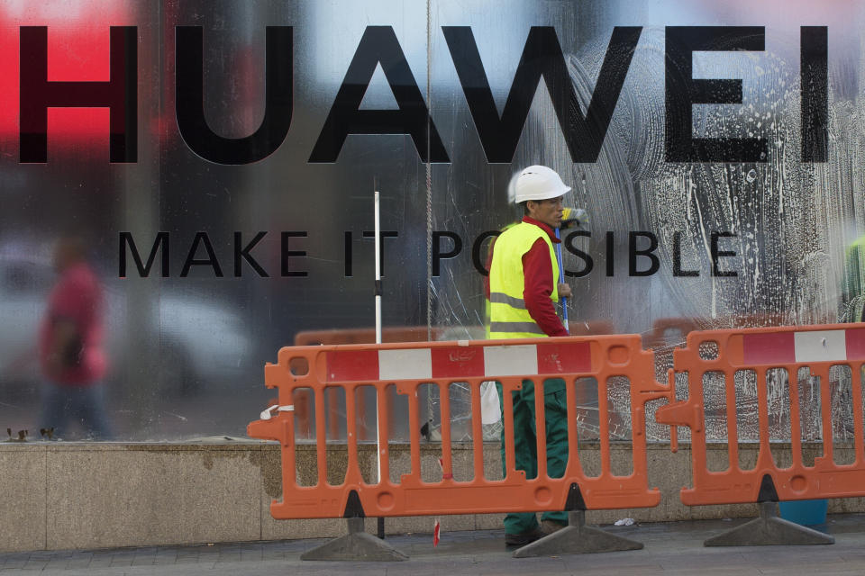 Workers clean the front of the new Huawei flagship store due to open soon in Madrid, Spain, Wednesday, May 22, 2019. The Trump administration sanctions against Huawei have begun to bite even though their dimensions remain unclear. U.S. companies that supply the Chinese tech powerhouse with computer chips face a drop in sales, and Huawei's smartphone sales could get decimated with the anticipated loss of Google's popular software and services. (AP Photo/Paul White)