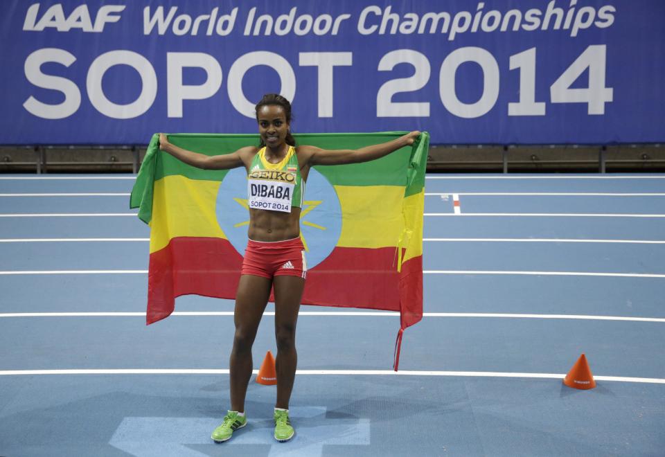 Ethiopia's Genzebe Dibaba celebrates with her country's flag after winning the gold medal for the women's 3000m during the Athletics Indoor World Championships in Sopot, Poland, Sunday, March 9, 2014. (AP Photo/Matt Dunham)