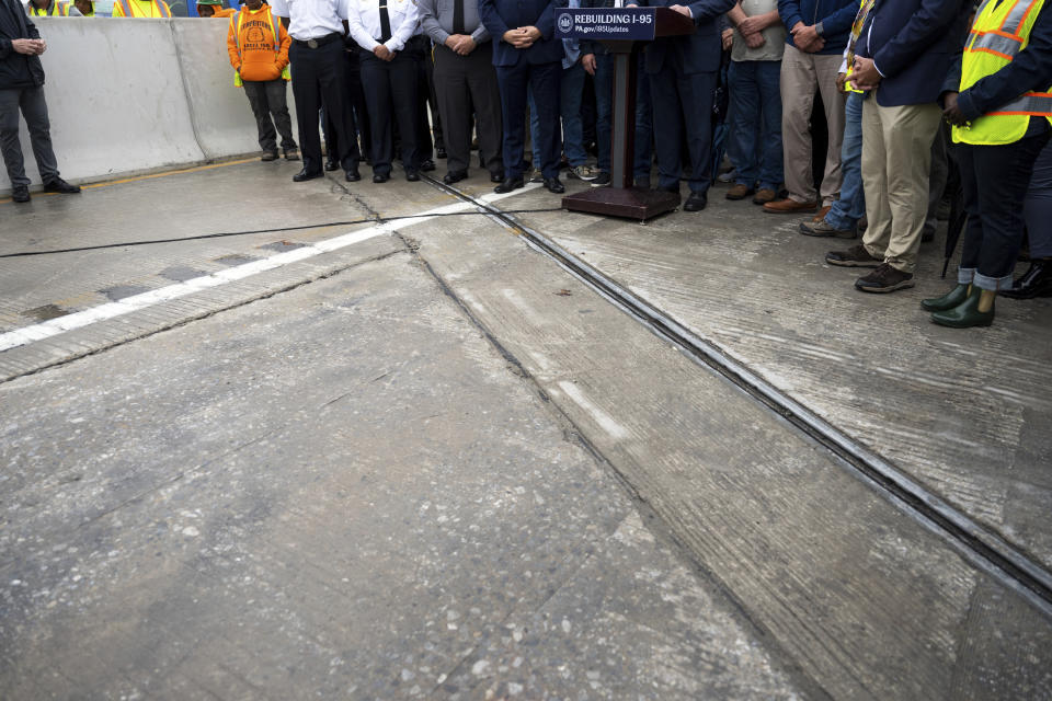 A news conference is held on the highway to announce the reopening of Interstate 95 Friday, June 23, 2023 in Philadelphia. Workers put the finishing touches on an interim six-lane roadway that will serve motorists during construction of a permanent bridge. (AP Photo/Joe Lamberti)