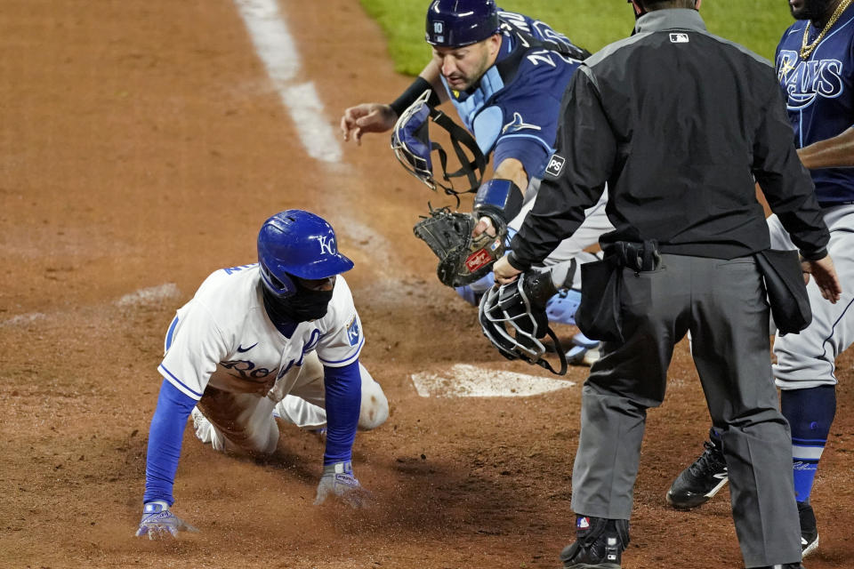 Kansas City Royals' Jarrod Dyson scores next to Tampa Bay Rays catcher Mike Zunino for the tying run on a sacrifice bunt by Nicky Lopez during the ninth inning of a baseball game Wednesday, April 21, 2021, in Kansas City, Mo. The Royals won 9-8. (AP Photo/Charlie Riedel)